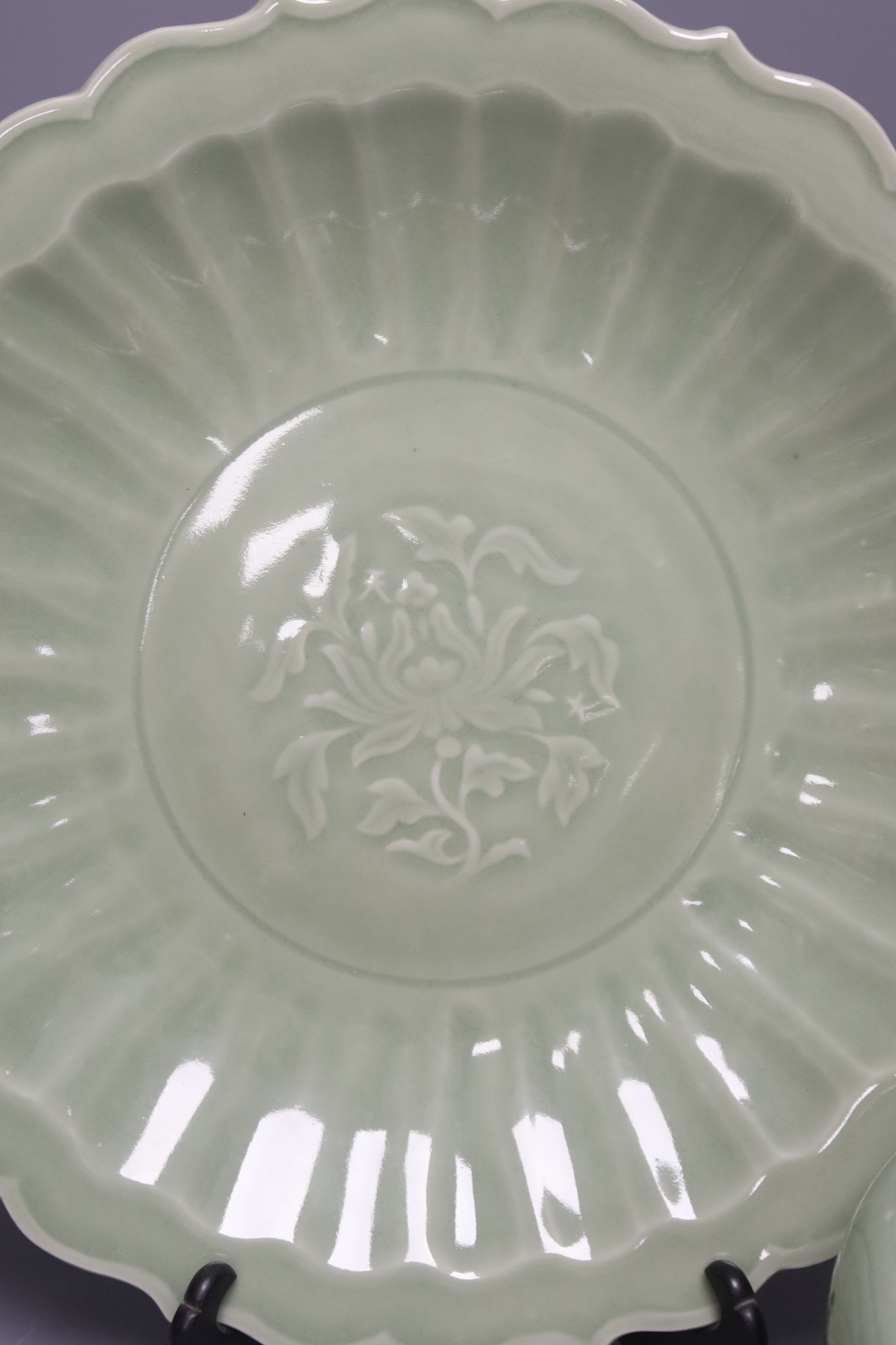 A Chinese circular celadon dish with scalloped rim, diameter 36cm, and a similar bowl, both with stands